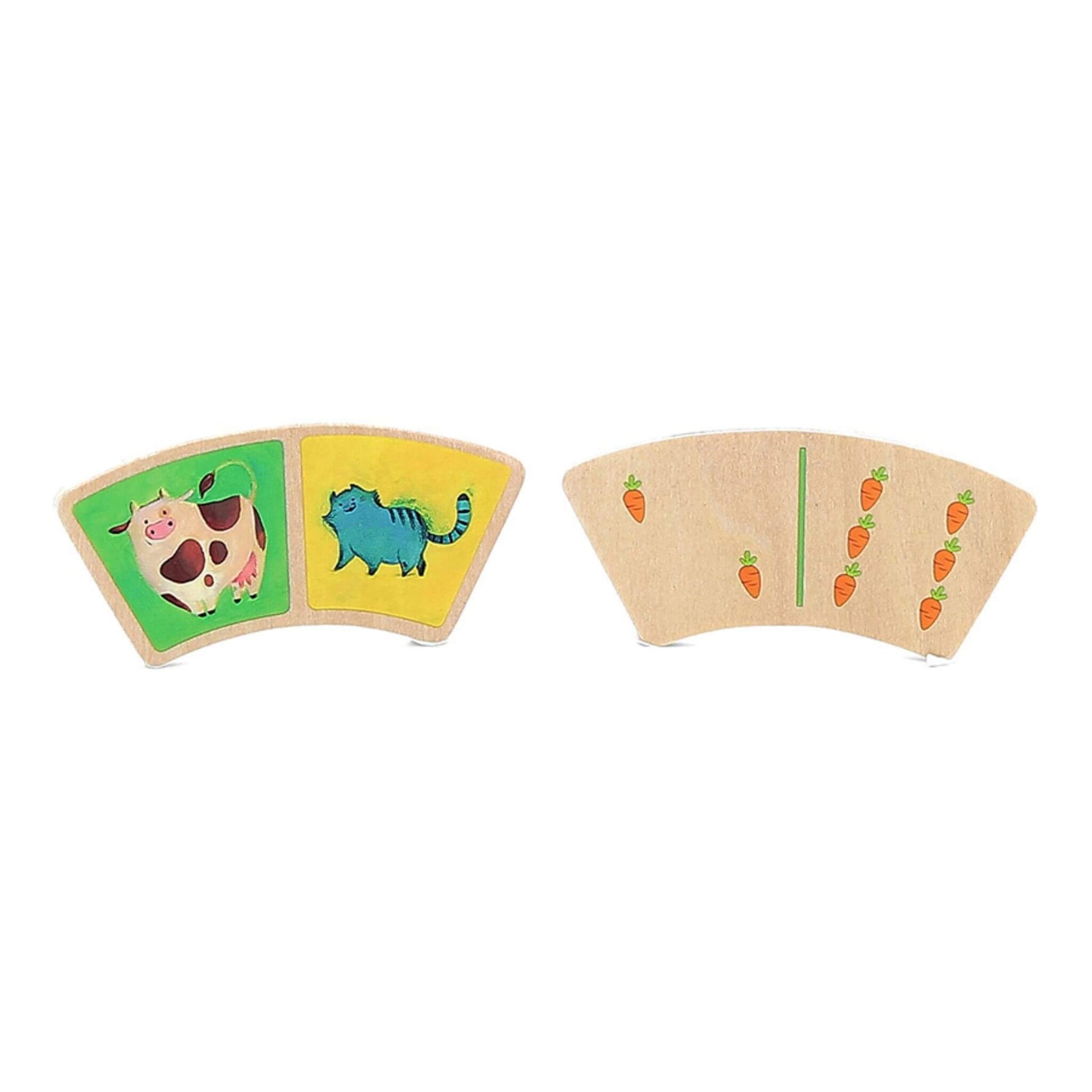 Two dominoes, featuring wooden tiles illustrated with a cow, a cat, and carrots.