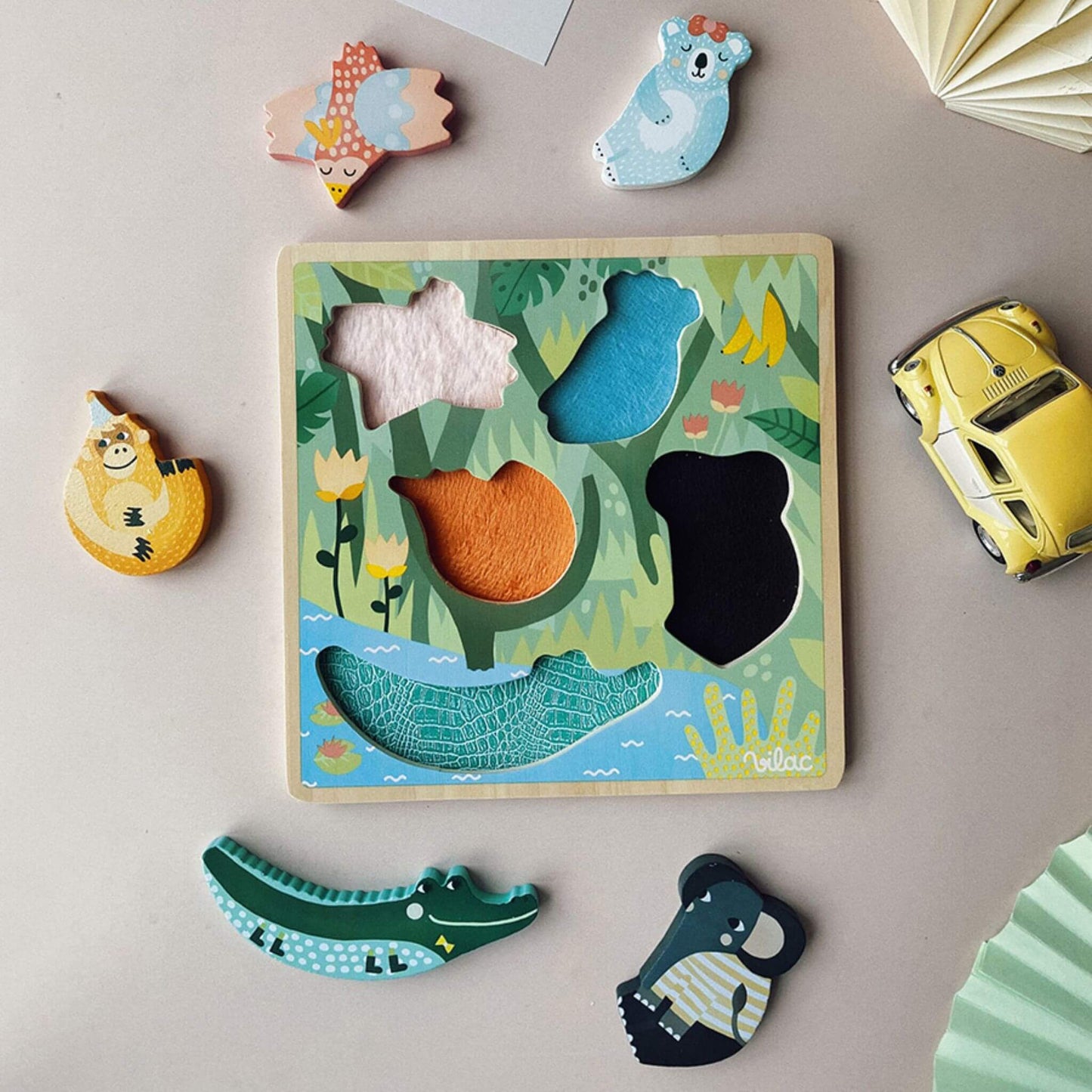 A Touch and Feel Puzzle displayed with colourful wooden animal pieces and a tactile jungle-themed board on a table.
