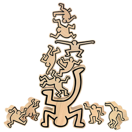 Wooden stacking figures arranged in a tall, unsteady tower with Haring’s outlined characters balanced on top of each other.