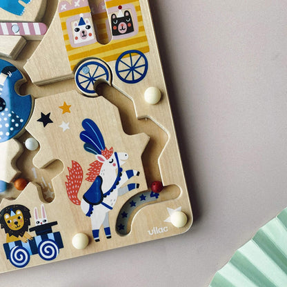 Close-up of the bottom right corner of the circus magnetic maze, showing a prancing white horse in costume, a lion and rabbit in a cart, and coloured beads on tracks.