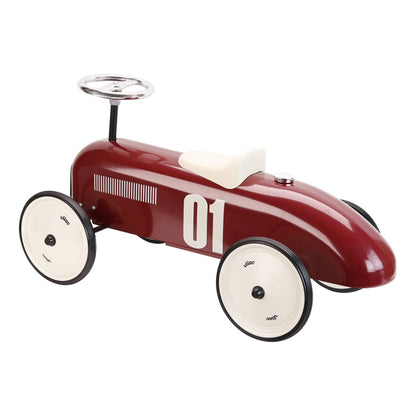 Rear angled view of a burgundy ride-on toy car with cream wheels, chrome steering wheel and number 01 decal, set against a plain background.