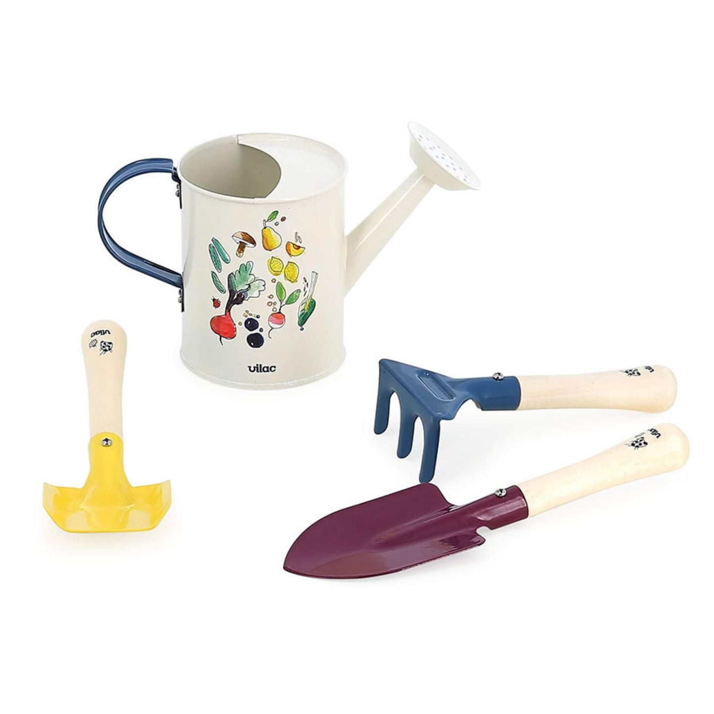 A small white toy watering can decorated with colourful fruit and vegetables shown alongside a yellow spade, purple trowel and blue hand rake with wooden handles.