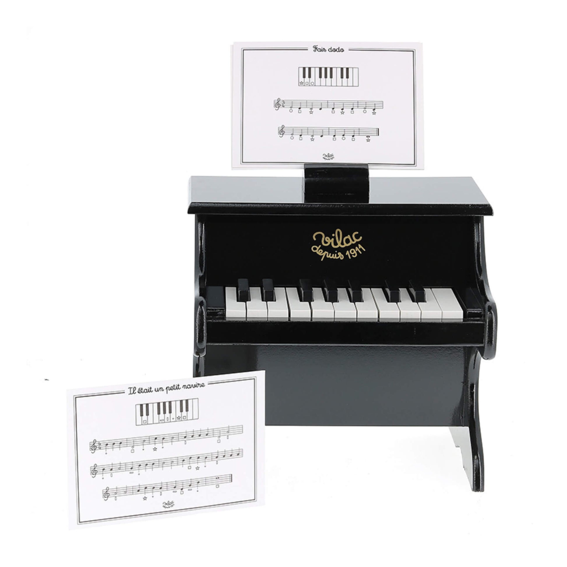 Front view of a small black wooden toy piano with white and black keys, featuring a music score card resting on a holder above the keyboard.