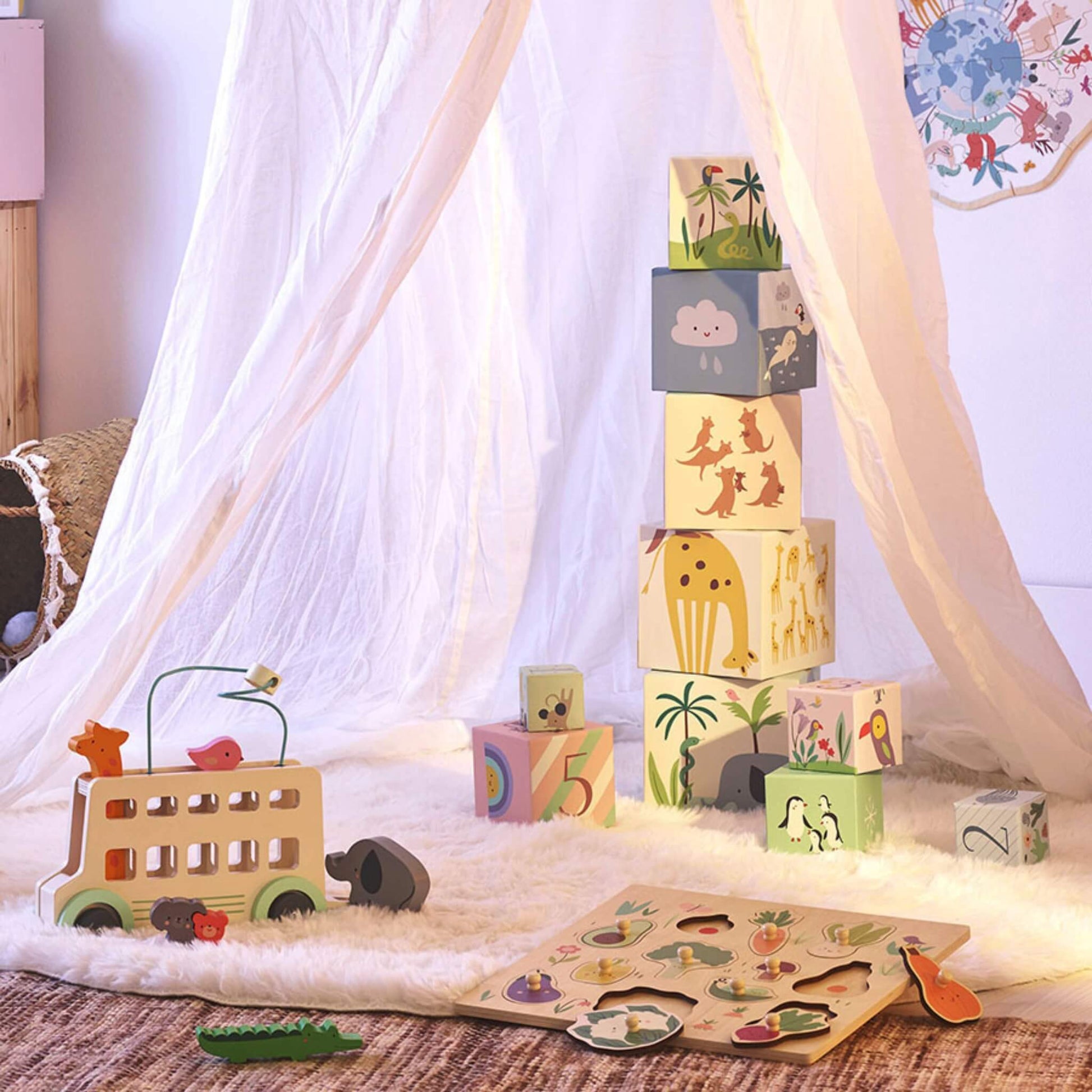 Children’s play tent with stacking blocks arranged on a rug alongside wooden toys.