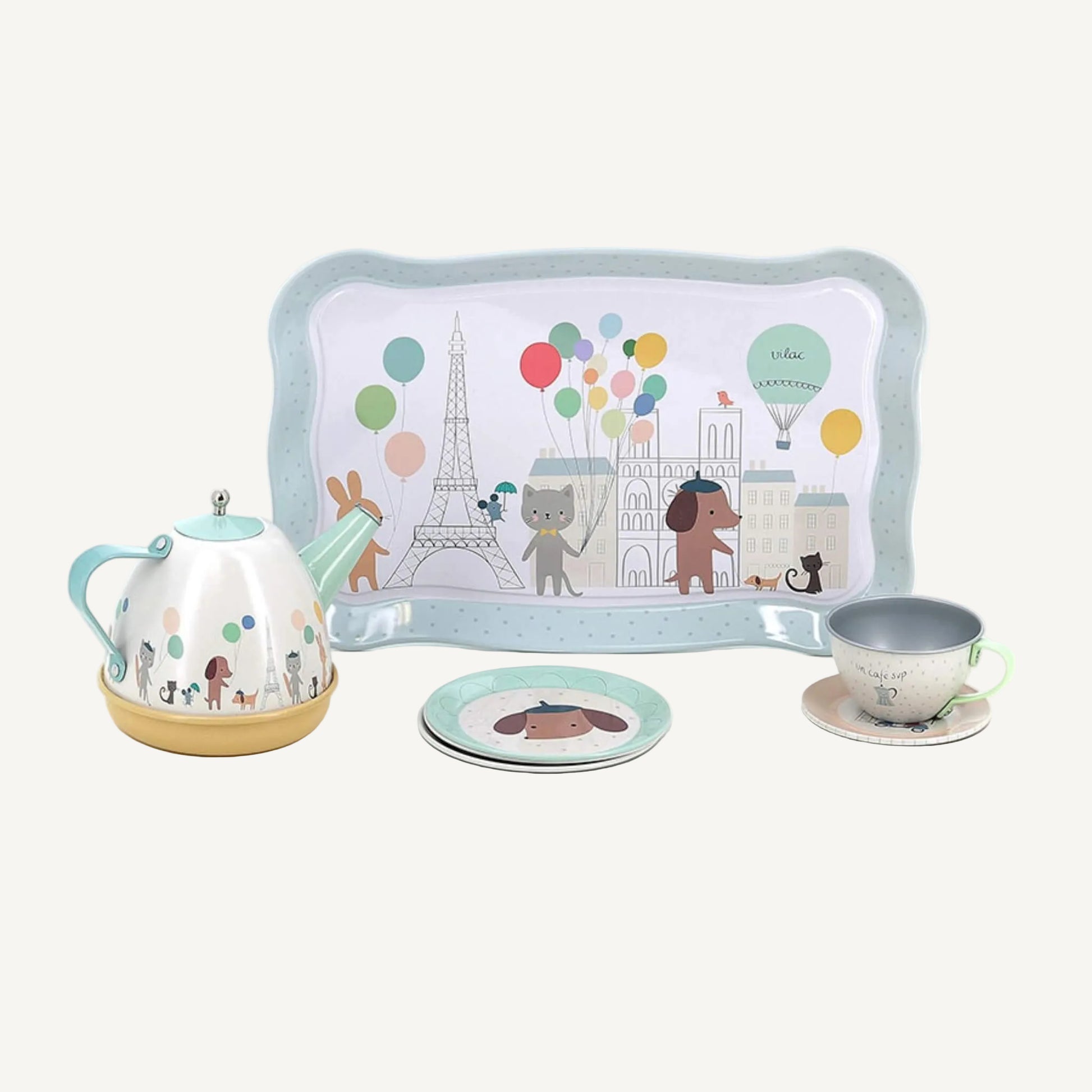 Pastel metal tea set tray with Eiffel Tower, balloons and animal illustrations beside teapot and cup.
