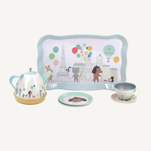 Pastel metal tea set tray with Eiffel Tower, balloons and animal illustrations beside teapot and cup.
