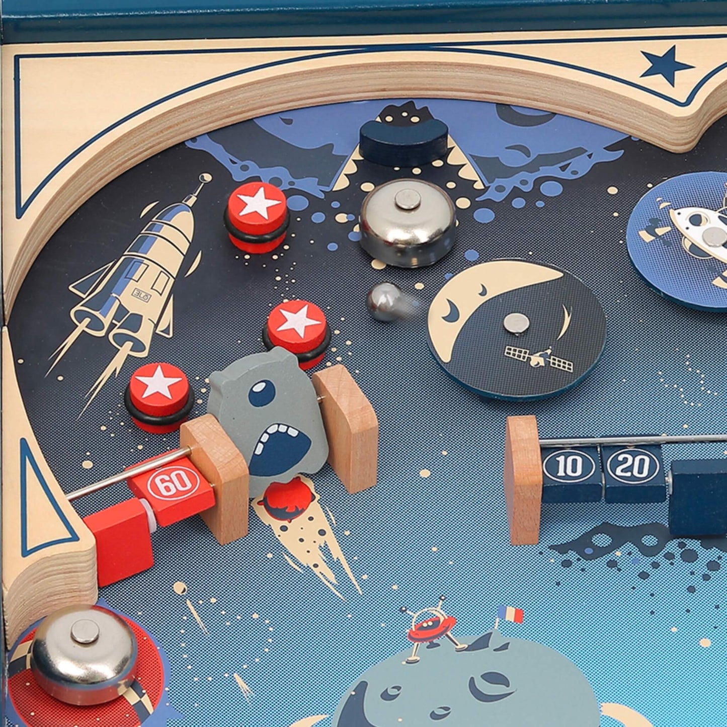 Upper section of pinball game showing bumpers, bell and space-themed artwork with moon and rockets.