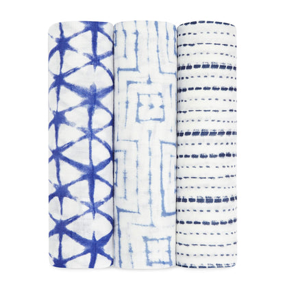 Aden + Anais Silky Soft Swaddles 3-Pack in Indigo, showing three rolled swaddles with tie-dye style geometric patterns in shades of deep blue and white.