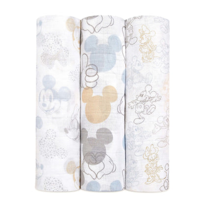 Set of three aden + anais Boutique Cotton Muslin Swaddles featuring Mickey and Minnie Mouse prints in soft pastel tones.
