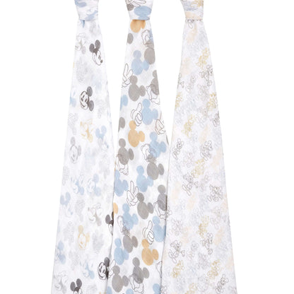 Three aden + anais cotton swaddles hanging to show full Mickey and Minnie print designs in grey, blue, beige, and gold tones.