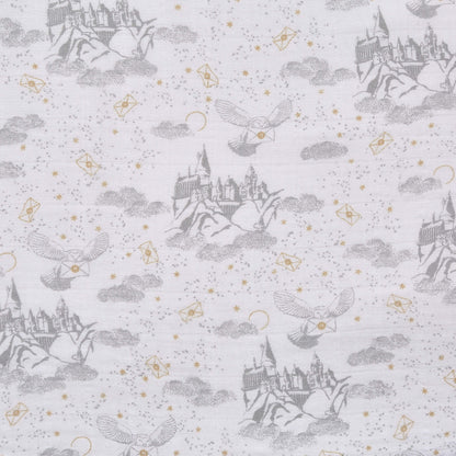 Detailed fabric swatch showing grey Hogwarts™ castle, clouds, and owls carrying letters from the aden + anais Harry Potter™ swaddle collection.