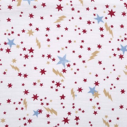 Close-up of aden + anais Harry Potter™ muslin fabric featuring red stars, gold lightning bolts, and blue stars on a white background.