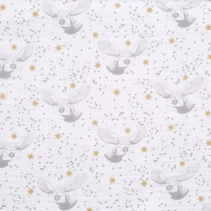 Detailed fabric swatch of aden + anais Harry Potter™ muslin with grey Hedwig owls carrying letters, gold stars, and grey speckles on white background.