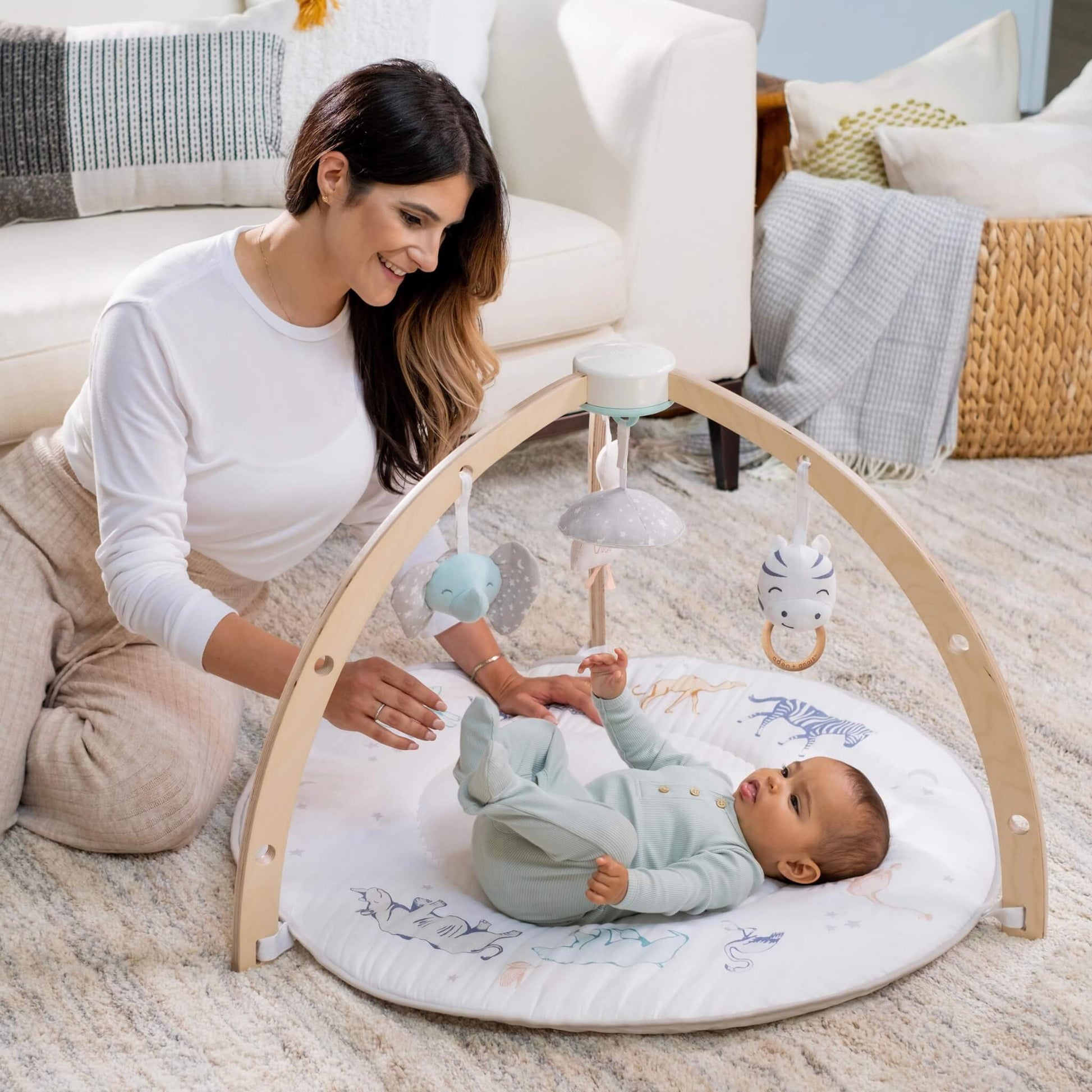 Mother and baby bonding on the aden + anais Rising Star Play Gym.