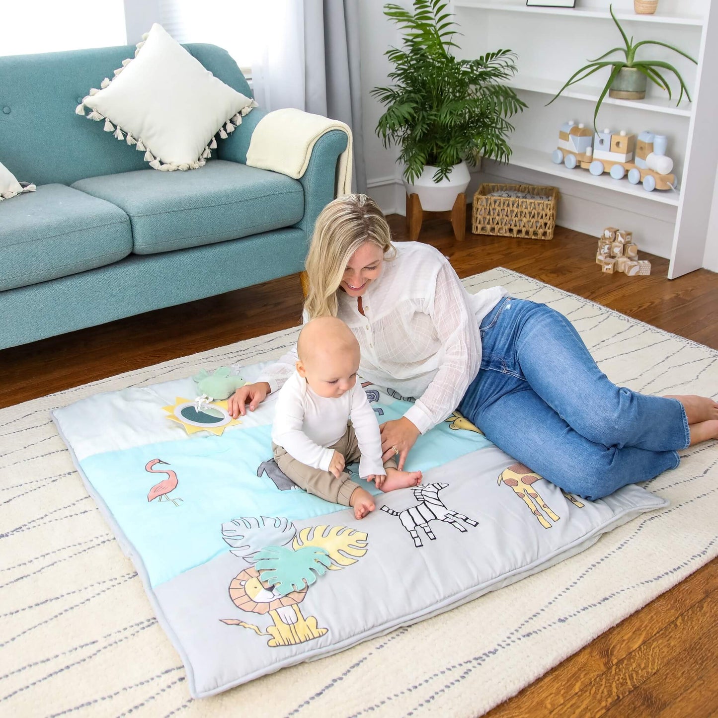 Mother and baby on the aden + anais baby bonding playmat with Jungle Jam animal print, enjoying floor time and early developmental play.