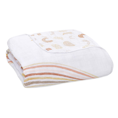 aden + anais Dream Blanket made from soft cotton muslin, featuring an earthy rainbow and sunshine print in warm neutral tones.
