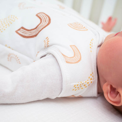 Side view of baby’s arm and shoulder wearing aden + anais Keep Rising sleeping bag. Shows sleeveless design and soft fabric details.