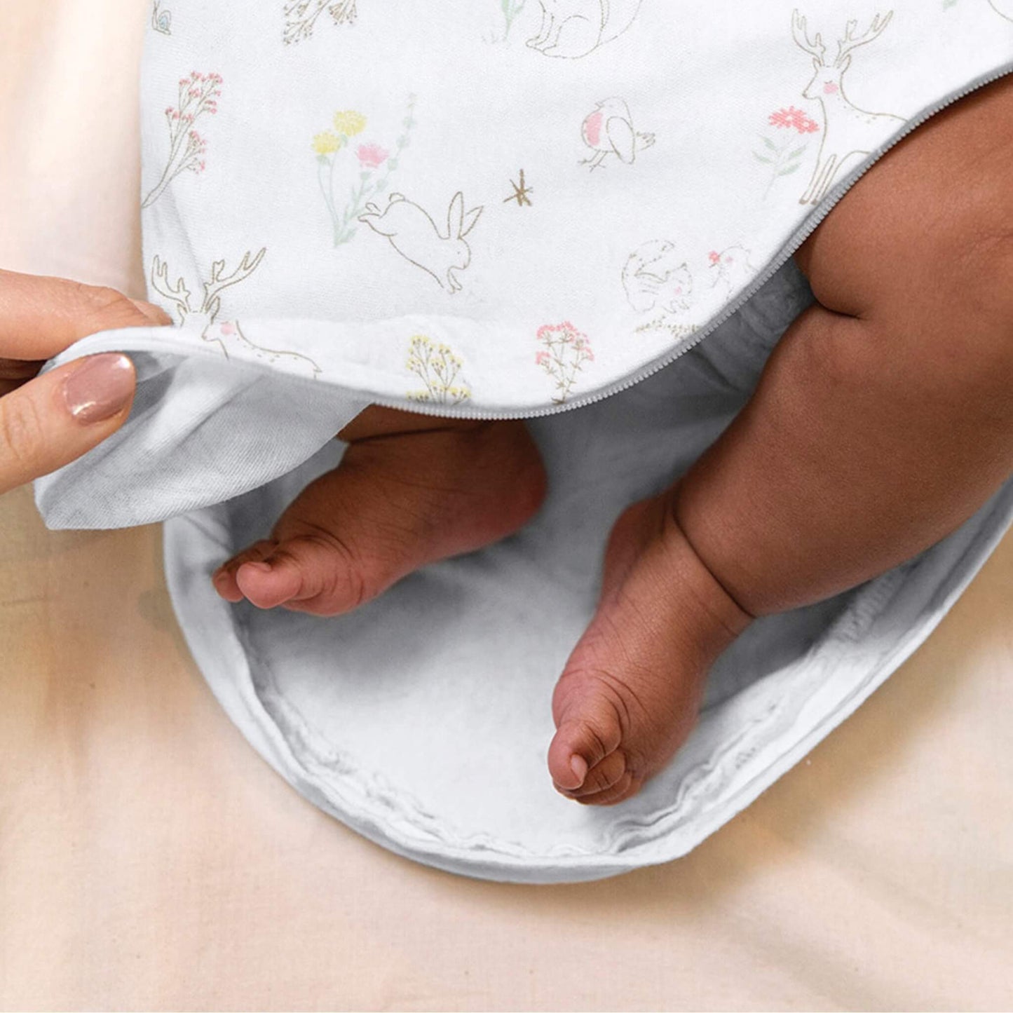 Close-up of baby's legs inside aden + anais swaddle, showing open zipper for easy nappy changes.