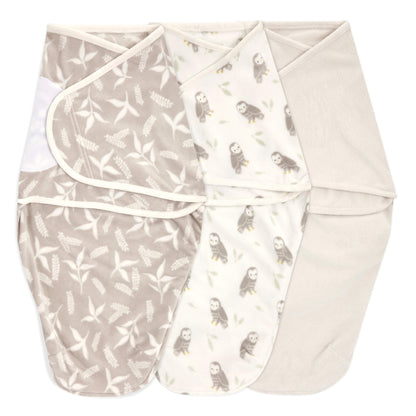 Flat lay of three velboa swaddle wraps in Rockland Marsh designs. Features abstract waves, bear motifs, and solid grey swaddle.