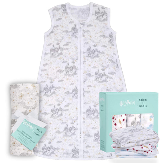 Soft cotton muslin sleeping bag with grey Hogwarts castle illustrations displayed alongside folded muslin squares and matching mint green packaging on a pale warm background.