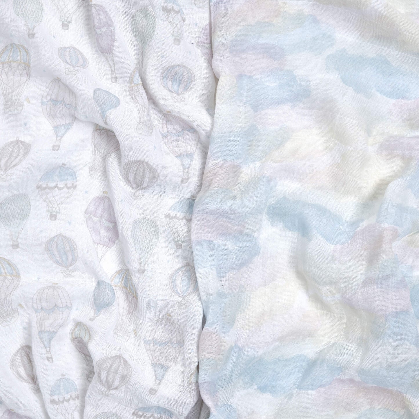 Close-up of aden + anais Above the Clouds organic muslin swaddles in balloon and pastel cloud prints. Soft, airy texture ideal for swaddling and everyday use.