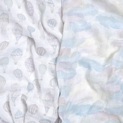 Close-up of aden + anais Above the Clouds organic muslin swaddles in balloon and pastel cloud prints. Soft, airy texture ideal for swaddling and everyday use.