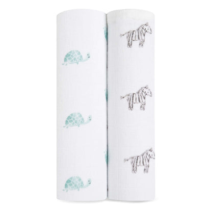 Close-up of aden + anais Animal Kingdom organic cotton swaddles, featuring turtles and zebras on soft white muslin.