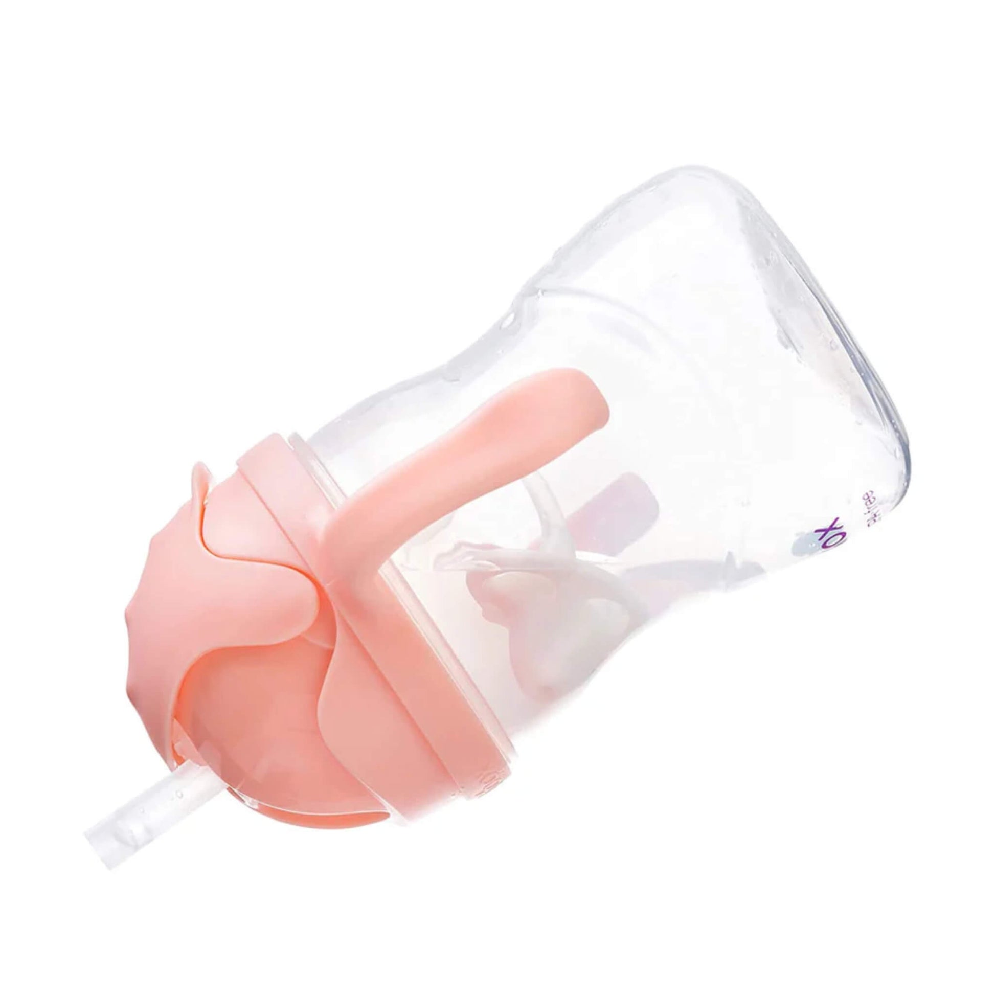 A sippy cup tilted on its side, showing the peach-pink lid, handles and the internal weighted straw.