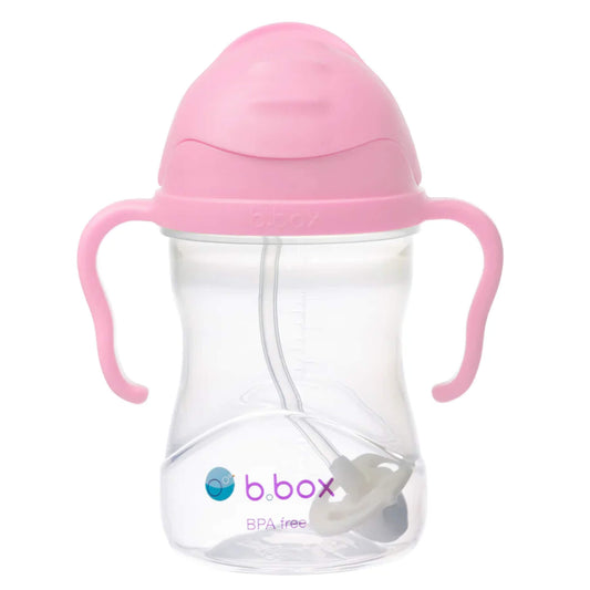 A pink-lidded sippy cup shown with the flip-top lid closed, clear body visible, and curved handles on each side.