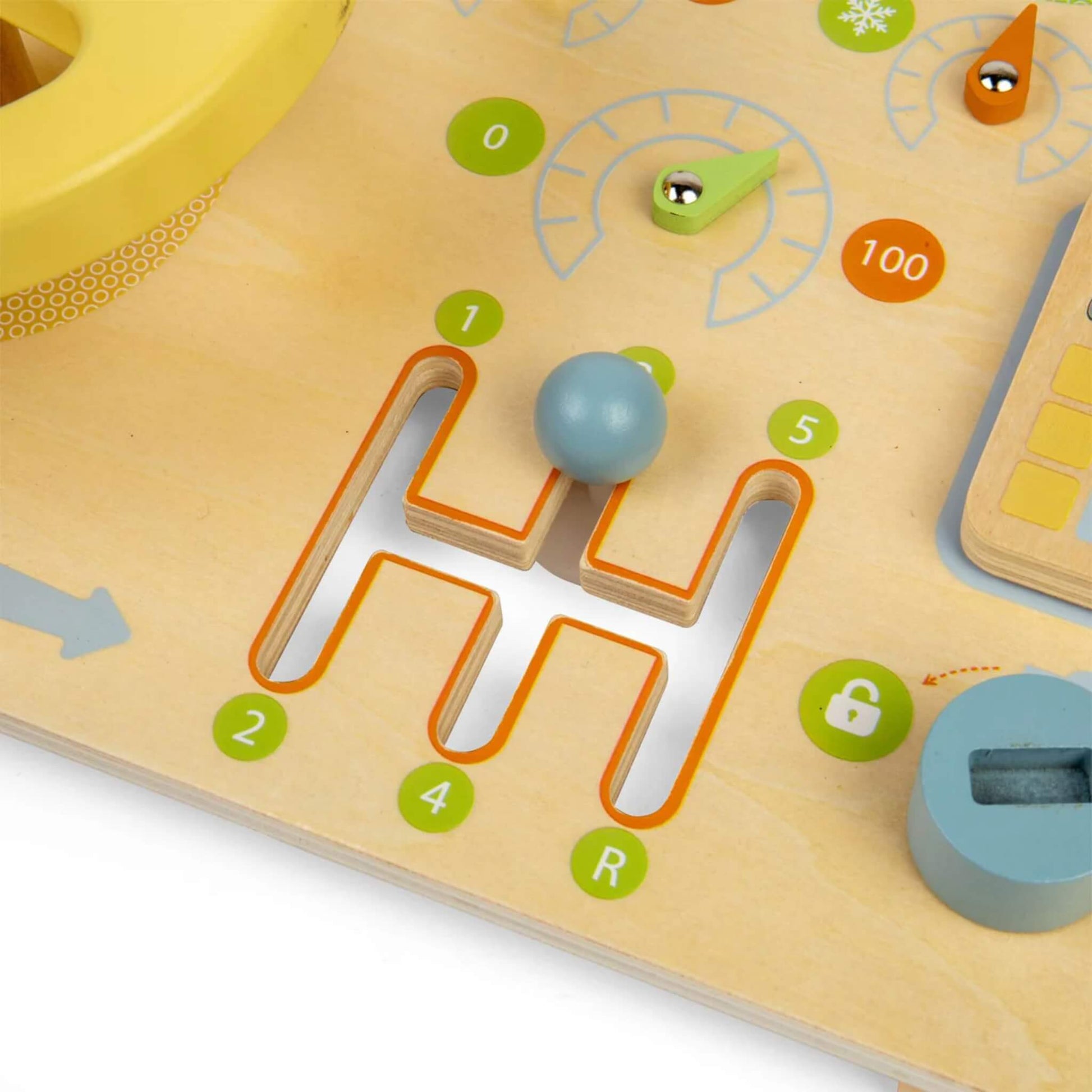 Close-up of a blue wooden ball sliding through an H-shaped maze track on a wooden activity board with colourful numbered details.