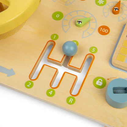 Close-up of a blue wooden ball sliding through an H-shaped maze track on a wooden activity board with colourful numbered details.