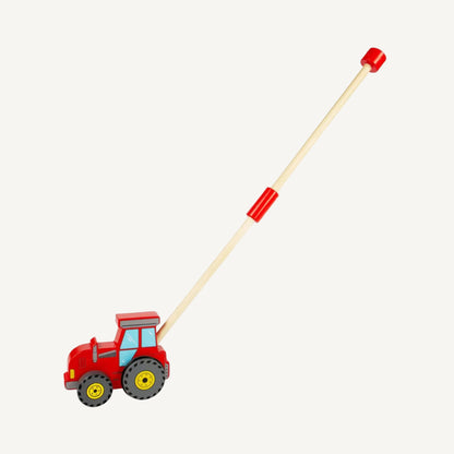 Red wooden tractor push along toy shown with a folded handle position, featuring chunky grey wheels, blue painted windows and a compact wooden design.