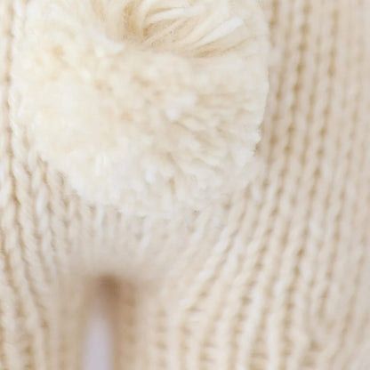 Close-up of knitted bunny tail showing soft yarn texture and detailed stitching.