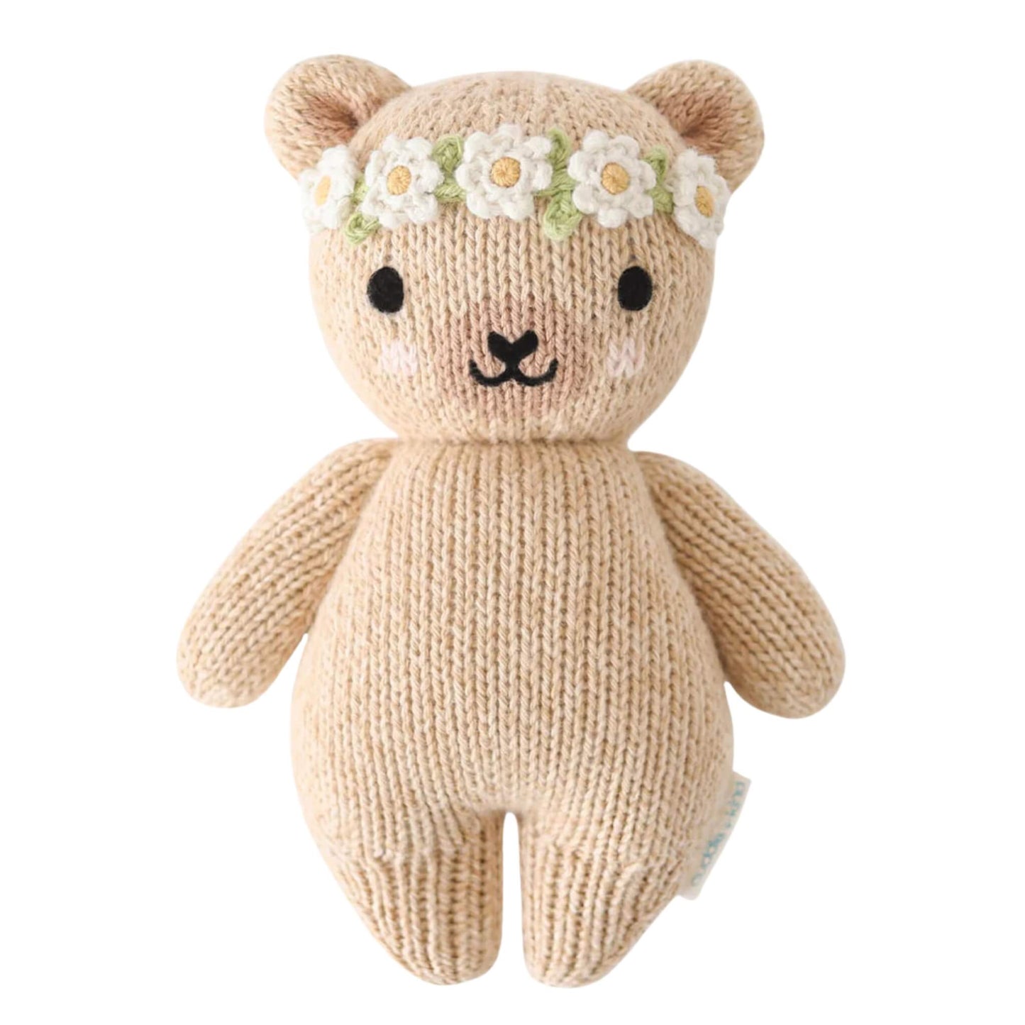 Cuddle + Kind Baby Animal Honey Bear Ivory Floral soft knitted teddy with stitched face and daisy flower crown on a neutral background.