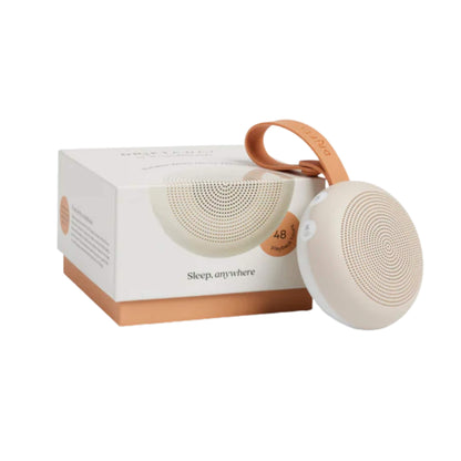 Small portable sound machine placed in front of its branded packaging, with the box showing the words “Sleep, anywhere” and a note of up to 48 hours playtime.