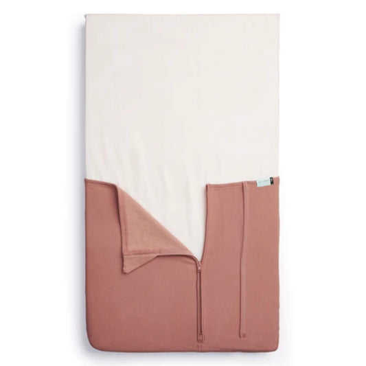 Top-view of the HugMe Blanket in rose laid to fit the mattress, with the zip partially open to display its fitted sleeve design.