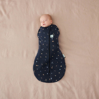 Baby wrapped snugly in a winter weight Cocoon Swaddle Bag with hedgehog print, zip-up front, and bell-shaped bottom.