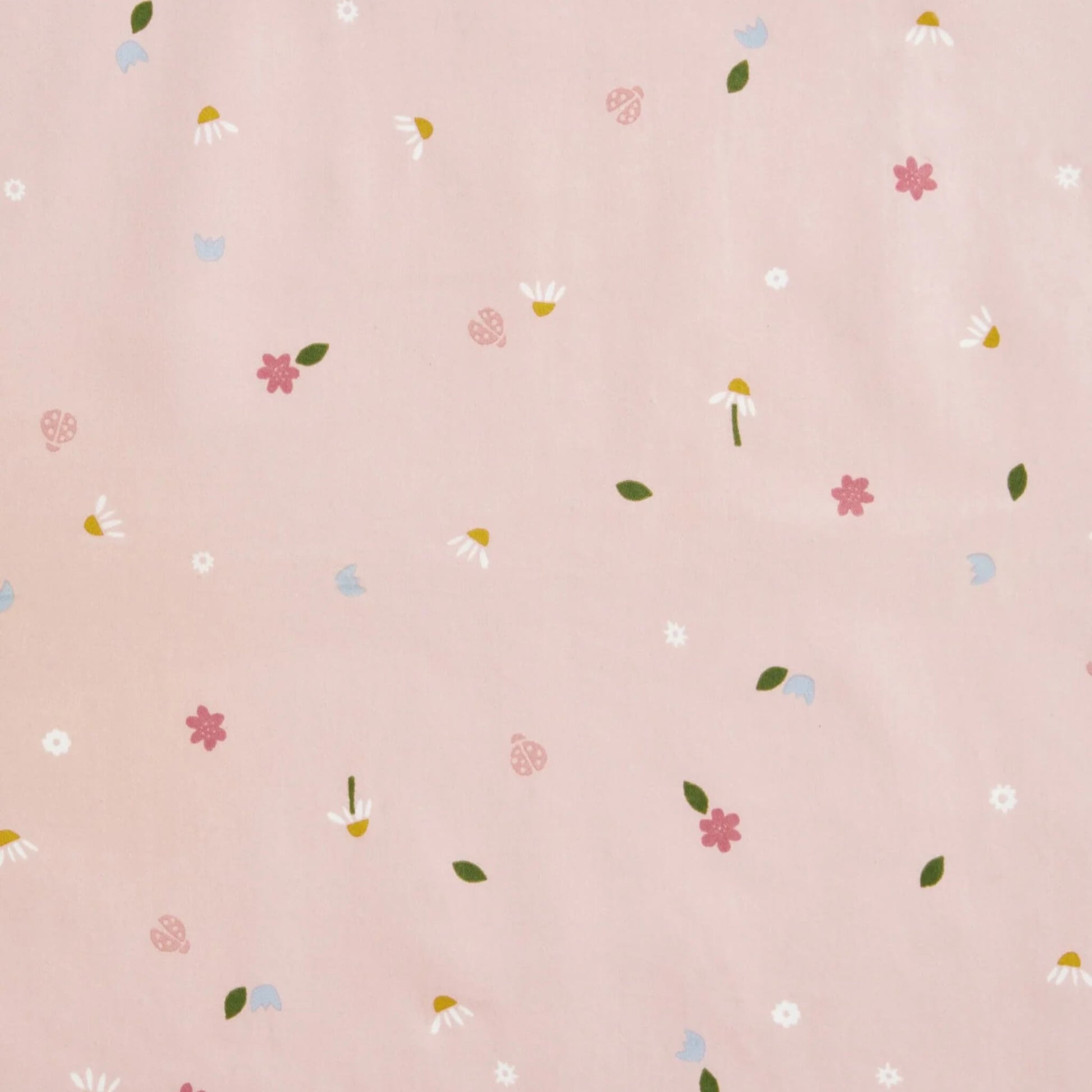 Fabric detail showing the daisy, flower, and ladybird pattern on the pink Cocoon Swaddle Bag.