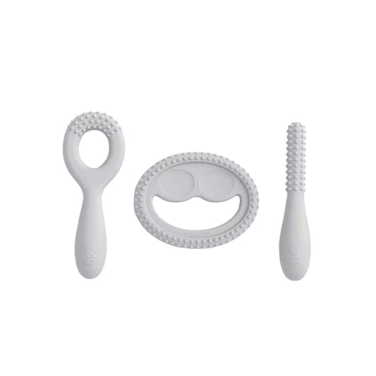 Ezpz Oral Development Tools in pewter grey including a loop teether, smile-shaped sensory teether and textured stick designed for early chewing and oral motor exploration.