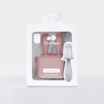 Retail packaging for baby popsicle mould set with blush silicone handles and infant feeding popsicle tool displayed inside box.