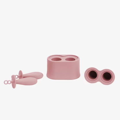 Blush silicone baby popsicle mould set showing stand, popsicle handles and removable silicone sleeves used to freeze breast milk, formula or purées.