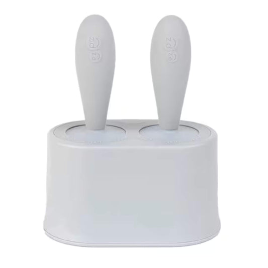 Ezpz Tiny Pops silicone baby popsicle mould set with two handles inserted into compact freezer stand designed for baby-led weaning portions.