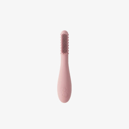 Ezpz Baby-Led Toothbrush in blush pink made from soft silicone, featuring textured sensory bumps and gentle bristles designed for babies learning early oral care.