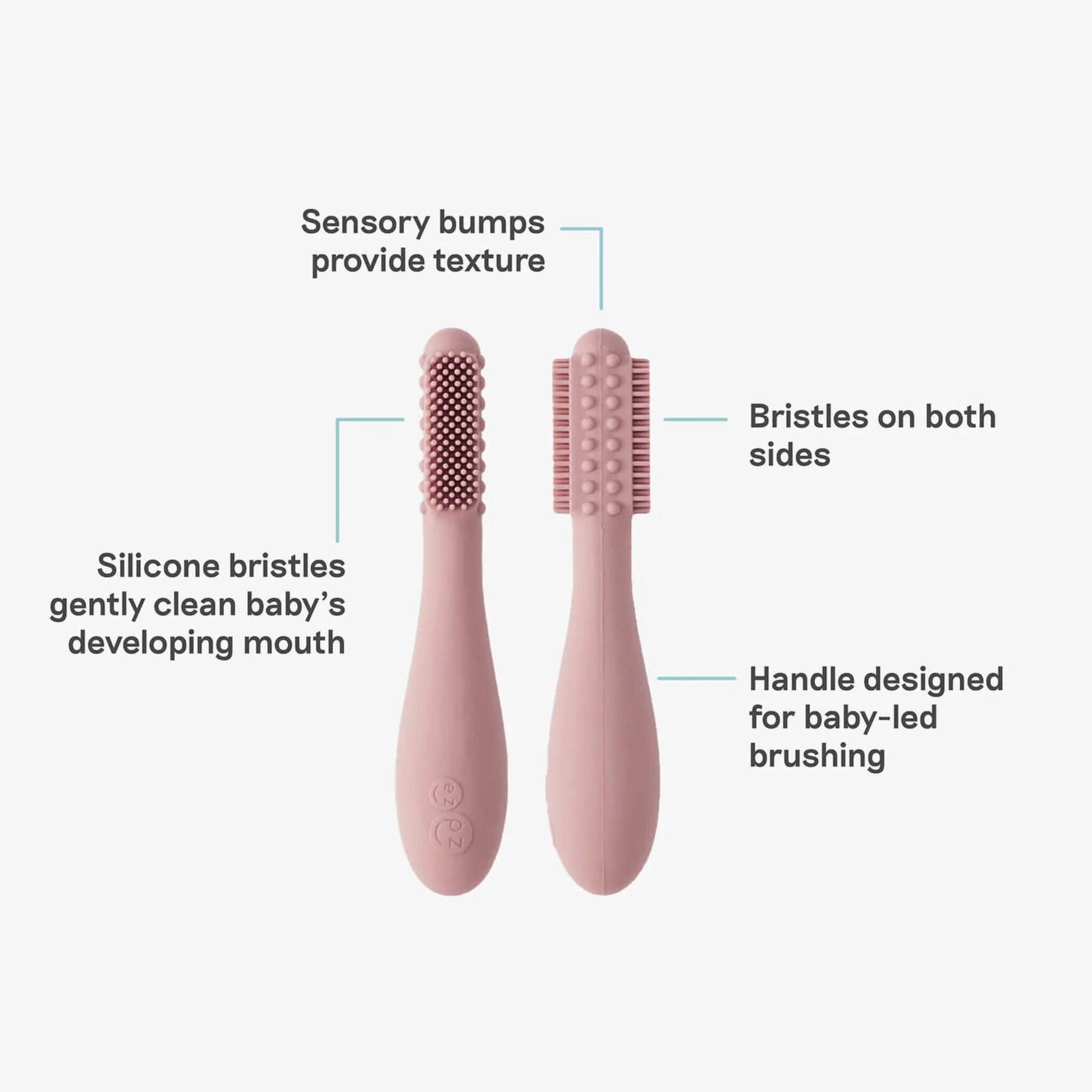 Two blush silicone baby toothbrushes displayed with labelled features showing sensory bumps for texture, silicone bristles for gentle cleaning and a handle designed for baby-led brushing.