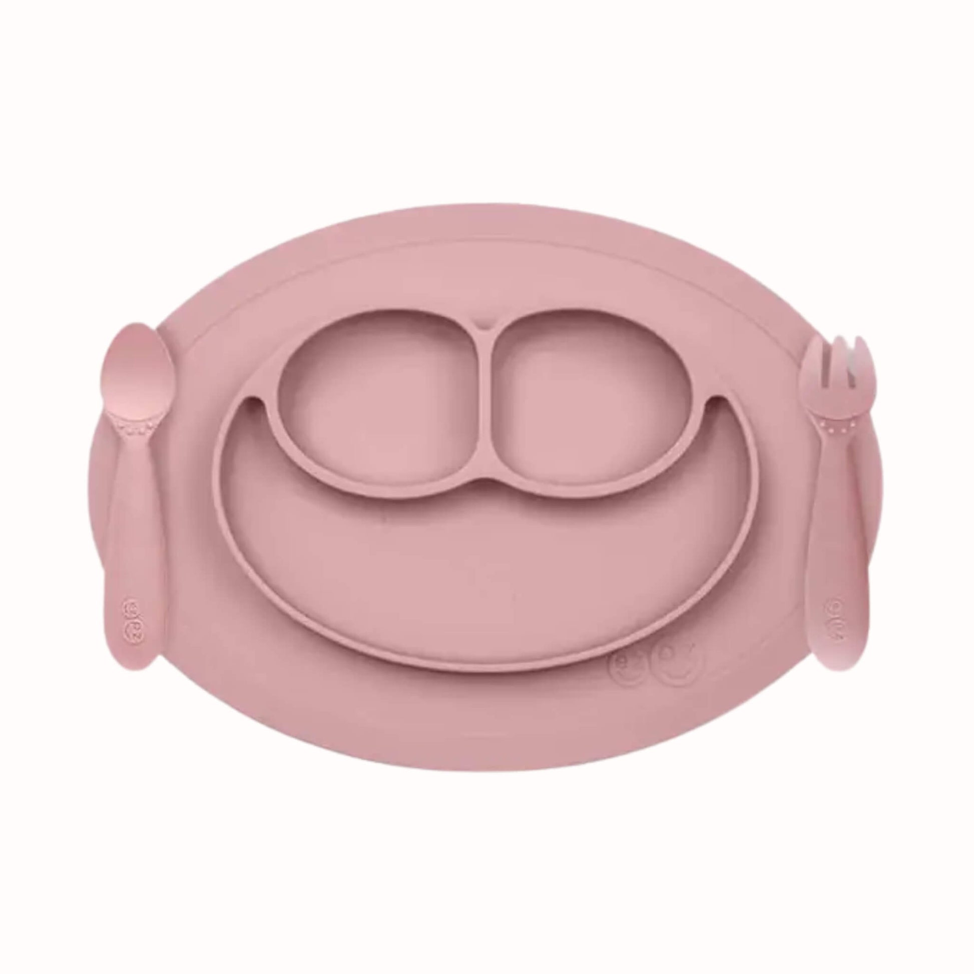 Silicone divided mini mat in blush with matching spoon and fork placed on either side for toddler self-feeding.