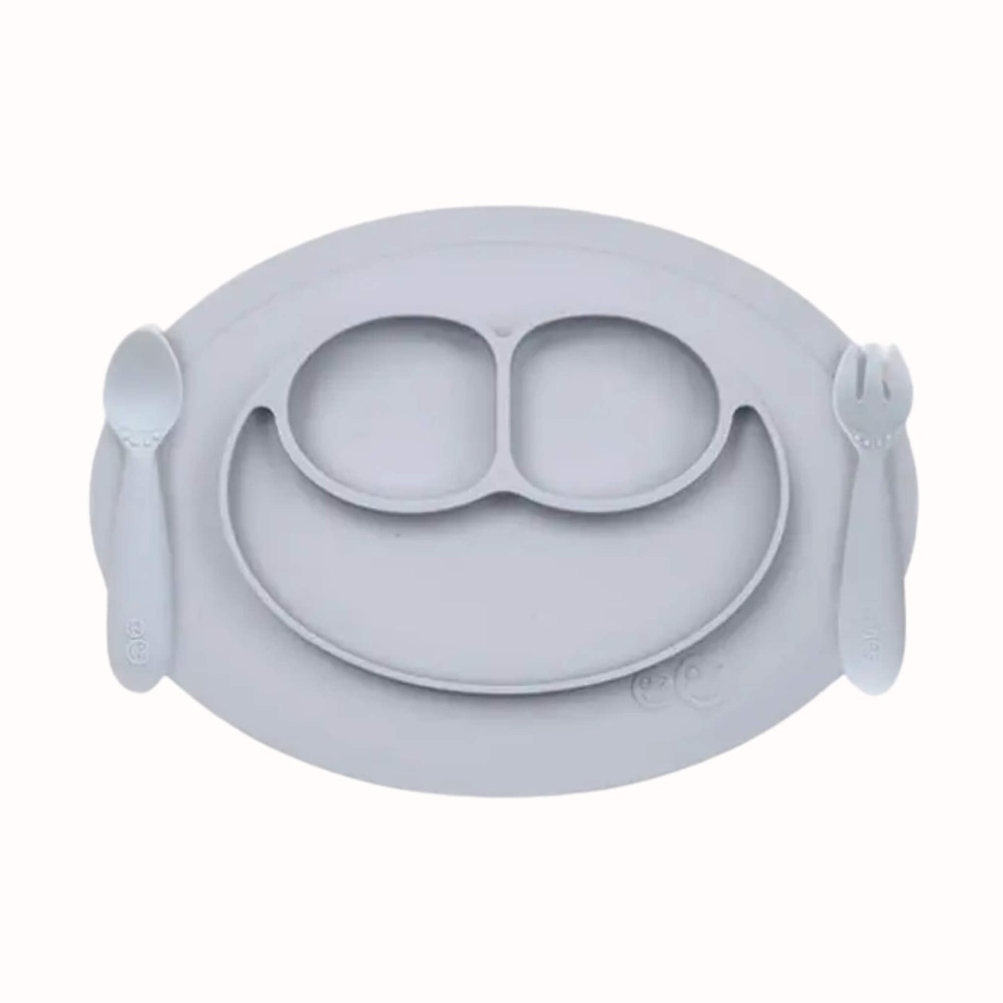 Silicone divided mini mat in pewter with matching spoon and fork placed on either side for toddler self-feeding.