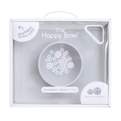Retail packaging box showing the Happy Bowl in pewter. The front displays a product illustration, the name “The Happy Bowl” and the description placemat + bowl in one.