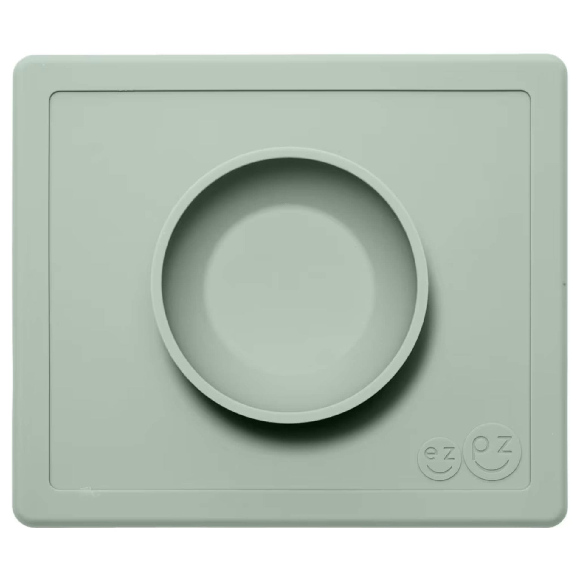 ezpz Happy Bowl in sage. A round silicone bowl is built into a rectangular placemat with the ezpz smiley face logo embossed in the corner.