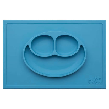 Ezpz Happy Mat in blue, a silicone placemat and plate in one with three compartments in a smiley face design to help children enjoy mealtimes.