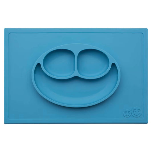 Ezpz Happy Mat in blue, a silicone placemat and plate in one with three compartments in a smiley face design to help children enjoy mealtimes.